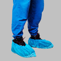 Persona usando cubrezapatos desechable con antiderrapante azul